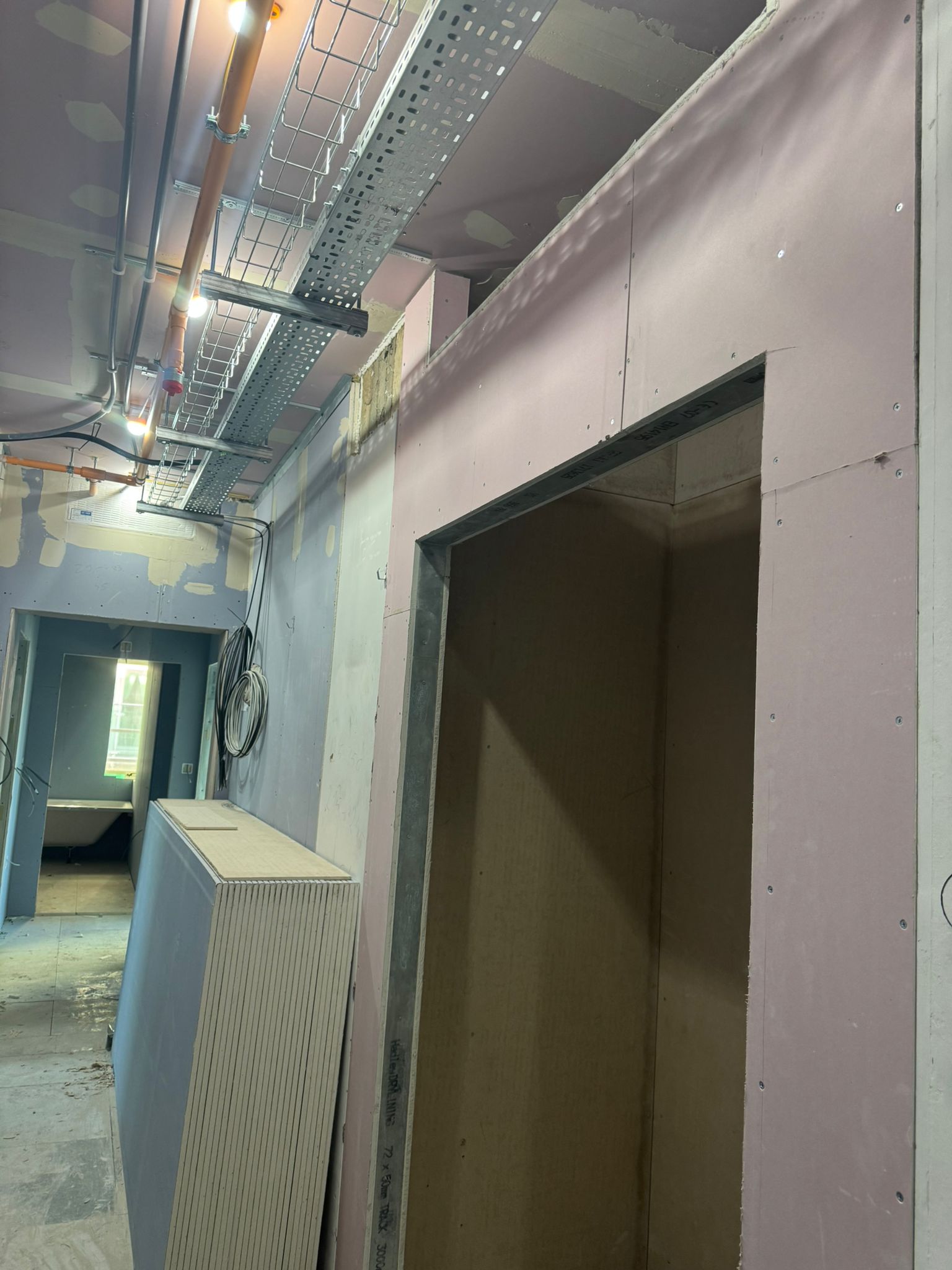 Plasterboard reveal around steel doorway lining